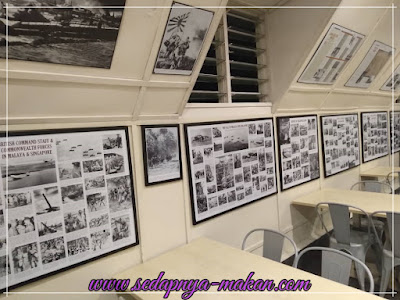 gambar-gambar di gantung di sepanjang dinding dalam bangunan barracks cafe