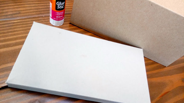 boxes glued inside out sitting on a table next to a glue stick