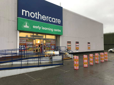 Exterior of out-of-town Mothercare store with closing down sale signs on display