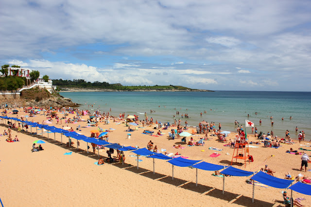 piaszczysta, długa plaża wypełniona urlopowiczami w pogodny, wakacyjny dzień 