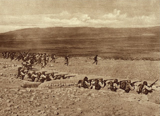 Sepia-toned photo of soldiers pointing rifles and moving out of trenches at Gallipoli