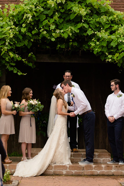 The bride and groom met in college, and have been together for three and a half years.  Maggie said that walking down the aisle towards Jordan was the best part of the day, knowing that they were surrounded by the love and support of friends and family.  She said, "As I walked towards him, Jordan and I were both tearing up and we couldn't look away from each other."  Jordan said that since he was "anxious all day, to the point of feeling sick," the first look was the most memorable part of the day.  He said, "The moment I saw Maggie, I felt 100% relieved, and it made the hours before the ceremony so much more enjoyable."    The Festivities Event Center in El Reno, OK, was the perfect wedding backdrop, with 10' windows, a whole second floor to get ready in, and a romantic setting for the outdoor nuptial.  The bride looked "drop-dead gorgeous" in her lace-embroidered, strapless, wedding gown, followed by her bridesmaids, dressed in individually designed gowns in soft hues of dusty rose.  Each bridesmaid had a spring floral bouquet, similar to the bride's bouquet of pastel pink roses and lilies.    After the couple exchanged wedding vows, pictures of the family and wedding party were taken, and it was time to celebrate!  First dances came next, then guests were invited to enjoy a Mexican buffet.  Dessert included the gorgeous wedding cake, chocolate groom's cake, and assorted, homemade cookies and pastries.  The evening came to a close as the guests sent the star-gazed couple off with sparklers!  The newly married couple escaped to Cozumel and Yucatan Progreso for their honeymoon.  