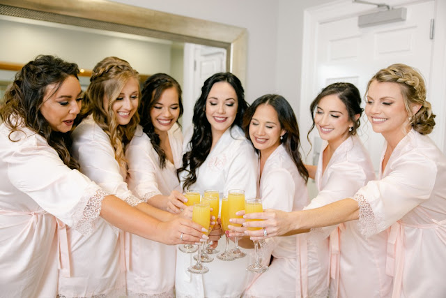 bride and bridesmaids toasting with mimosas