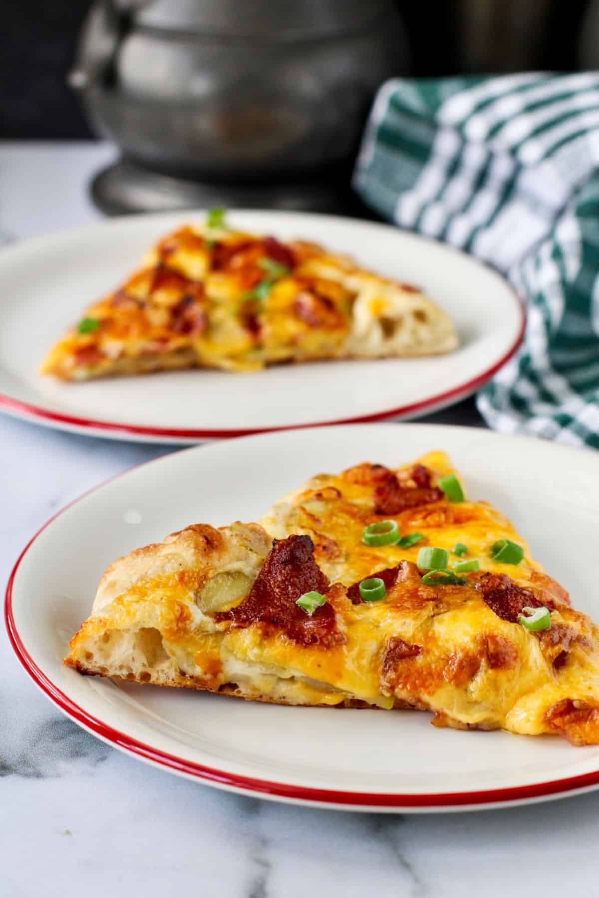 Loaded Baked Potato Pizza slices on plates.