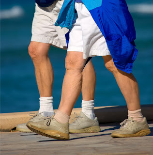 Image of an elderly couple brisk-walking for exercise.