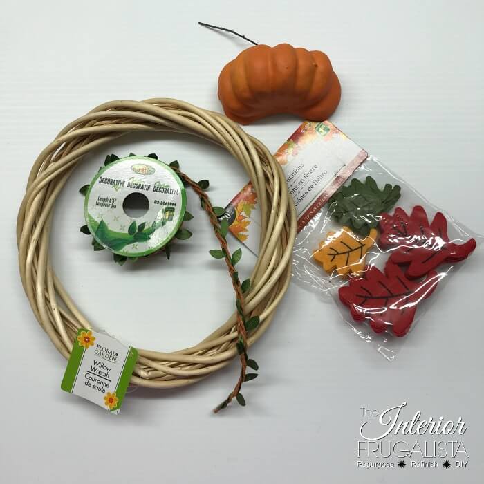 Turn inexpensive dollar store finds into an adorable small DIY Fall Pumpkin Wreath and it's so quick and easy to make in five minutes or less.
