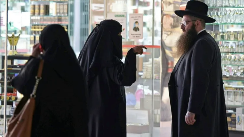 Rabino hassídico norte-americano Yaakov Israel Herzog conversa com uma mulher muçulmana totalmente coberta enquanto faz compras em um shopping na capital saudita, Riad | Fayez Nureldine/AFP