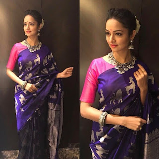 Woman wearing purple saree with pink blouse