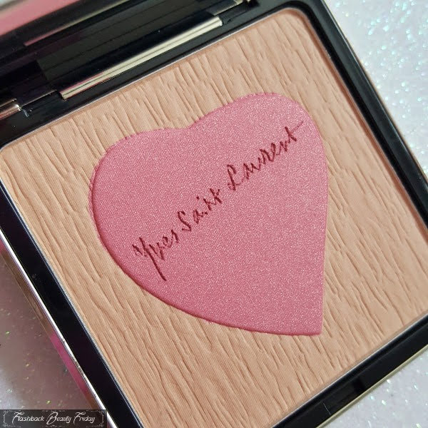 open powder compact with textured beige powder and pink shimmering heart in centre with engraved Yves Saint Laurent