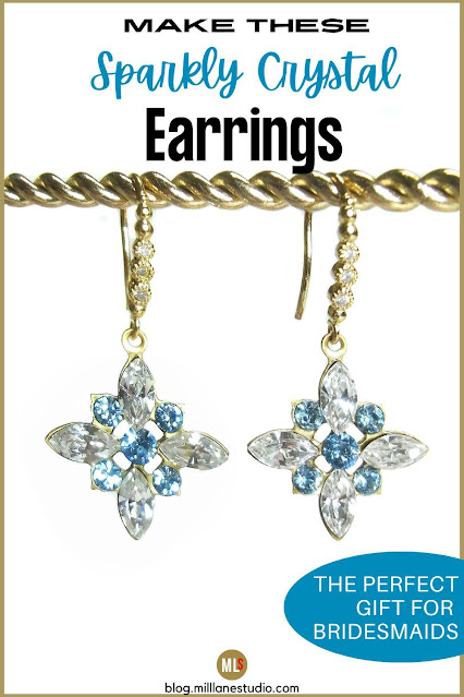Star-shaped aqua crystal earrings on gold earring wires dangling from a gold rope