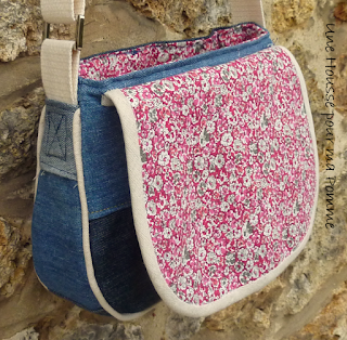 Sac à main Besace en jeans recyclés monté façon patchwork, intérieur coton liberty coloris rose, passepoil écru, une grande poches devant, rabat avec marque d'une poche arrière d'un jeans non délavée au file des lavage, entièrement doublé pour le rendre semi-rigide, anse coton écru, boucles couleur argent, surpiqures jaunes.   Dimensions : 24 x 18 x 7 cm environ