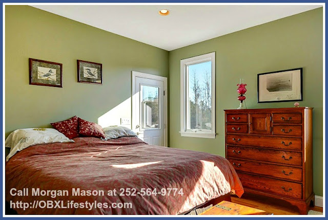 The master bedroom of this 4 bedroom equestrian property for sale on the Outer Banks NC has a walk-in closet, a large bathroom, and a private entry just off the enclosed back porch. 