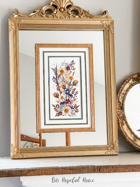 gold framed floral print attached to gold mirror