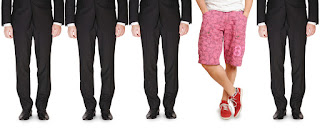 3 guys in business suits; 1 guy casually dressed in shorts