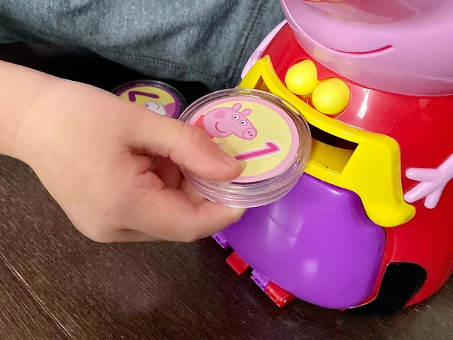 Close up of a preschooler hand pushing a coin into Count with Peppa