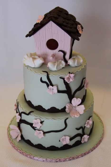 Pastel green and pink wedding cake with cute little birdhouse cake topper