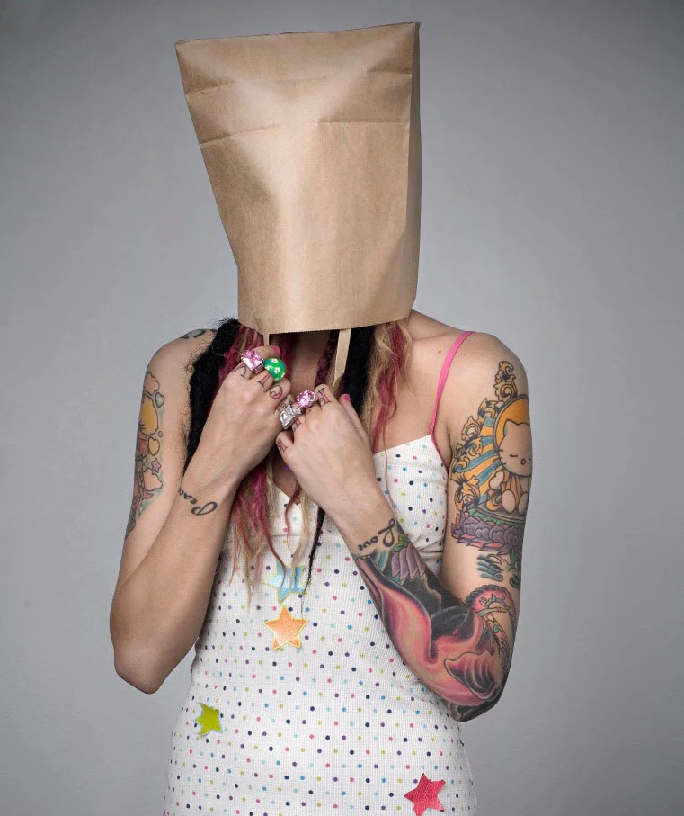 Chica tatuada se tapa la cabeza con una bolsa por verguenza