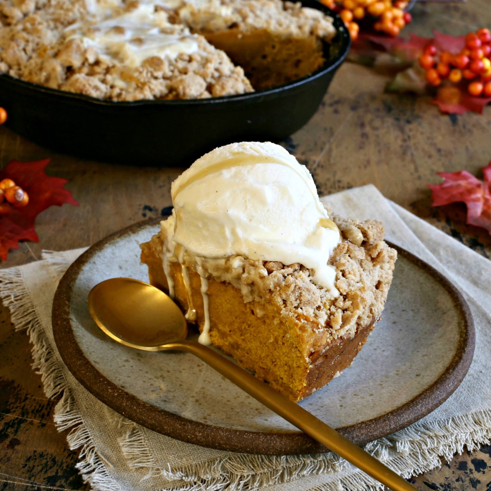 Recipe for a pumpkin cake with a crumb topping, served with honey vanilla ice cream swirled with honeycomb.