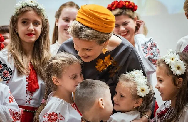 Fabienne Delvigne hat and Dries Van Noten grey yellow flower dress. Queen Mathilde and First Lady Diana Nausėdienė