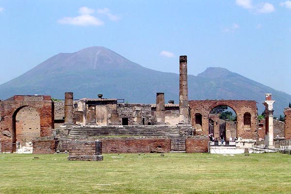 brick and stone ruins of a city or village, with large mountain rising behind