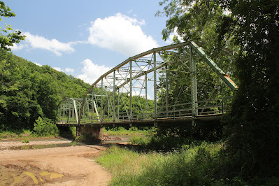 Image of an Iron Bridge over a stoney river