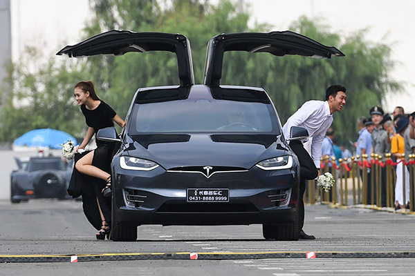 Una pareja de chinos en un tesla model x