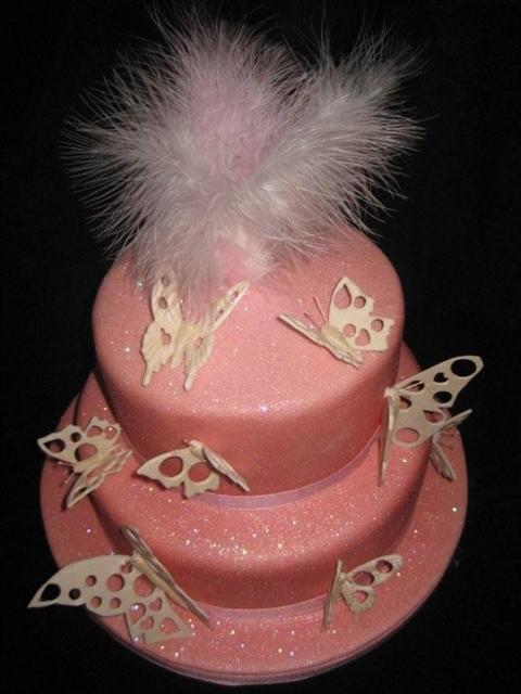 Glittery pink wedding cake with butterflies and a pale pink feather cake