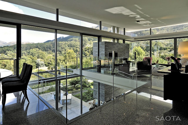 Picture of large interior area with living room and glass walls overlooking the hills