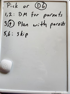 On a notebook-sized whiteboard is written, "Decide or D6  1,2 DM like usual 3,4 Planning session with support from parents 5,6 Skip"   "D6" is circled. "4" is circled.