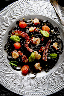 Tagliatelle de tinta de calamar con tomates y pulpo