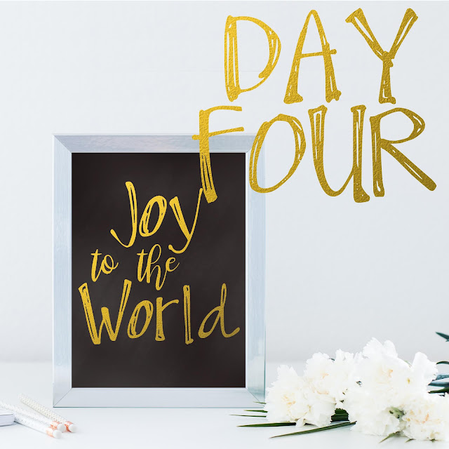 Joy to the world picture in frame on a table top with white flowers