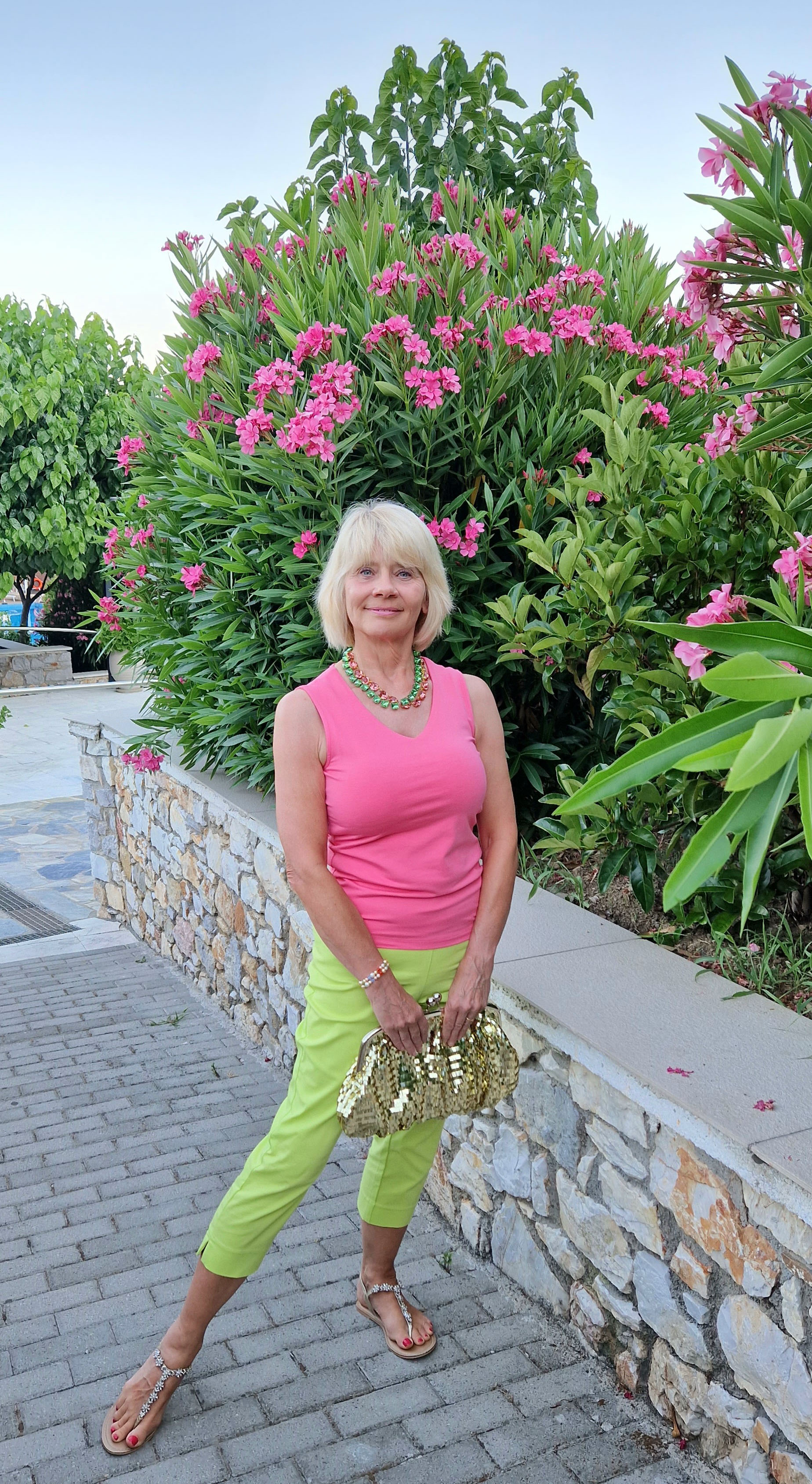 Lime green cropped trousers on holiday for Gail Hanlon from Is This Mutton among the bougainvillea