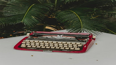 Red vintage workman typewriter in back garden work station.