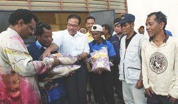 Welcome gift: Wan Rosdi (third from left) and Devamany distributing packs of rice to the orang asli at Pos Betau in Lipis recently