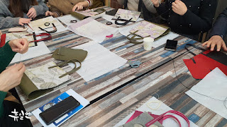 Visitors enjoying hands-on leather experience in a rural Korean workshop