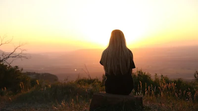 Imagem de uma pessoa em silêncio diante de um lindo pôr do sol