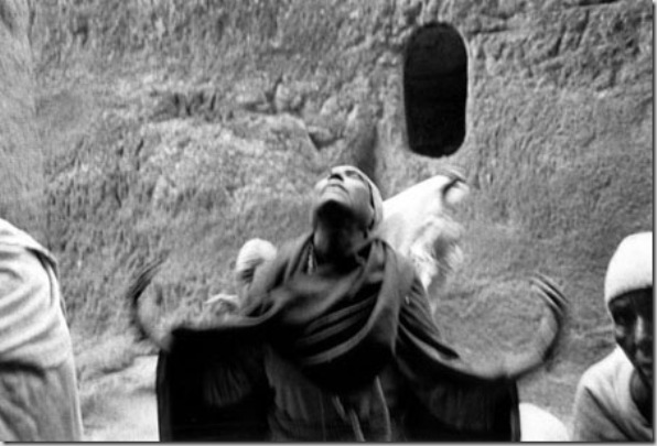 Pilgrim in a mystic trance in front of huge entry to Bet Madhane Alem rock-hewn church. For peasants that live in remote rural areas without communication the wonderful Lalibela produces a shock.