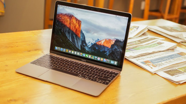 Macbook on a wooden table. It is silver colored, and this picture looks in a way to help advertise the macbook. Very high quality and professional.