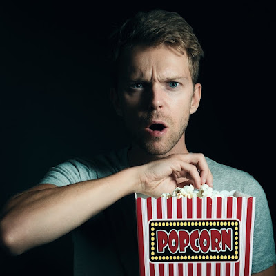 scared man holding popcorn
