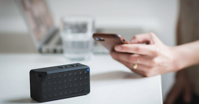 this is a picture of  a portable speaker being used witha mobile phone showing  it as a must have mobile phone accessory in 2023