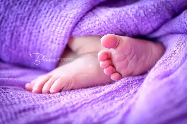 close-up of baby feet on purple blanket