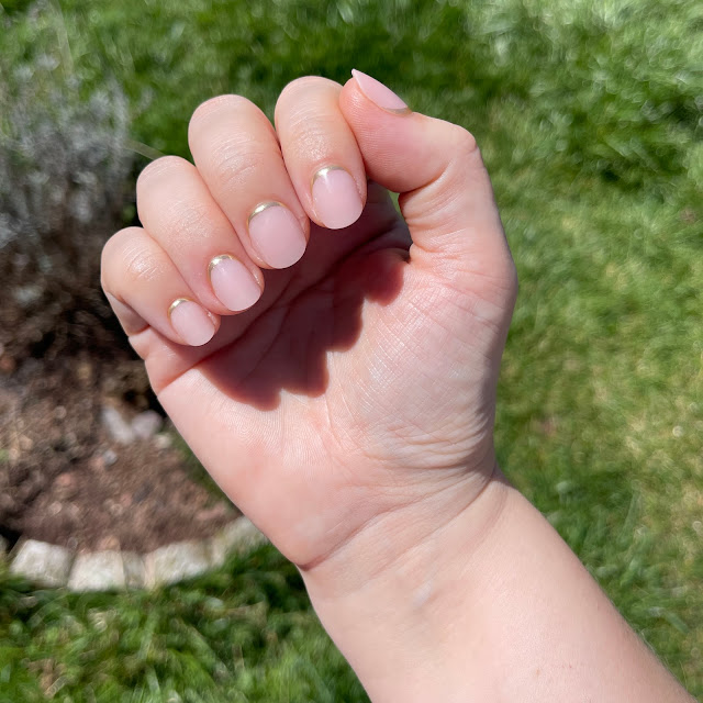 Glamnetic Goal Digger Nails on female hand over grass in the sun