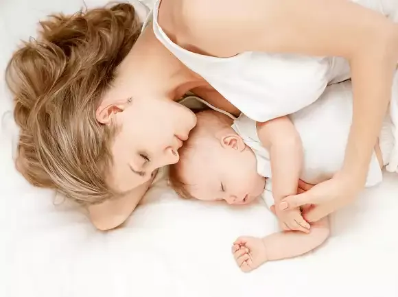 Uma mãe ou pai aconchegando o bebê em um ambiente acolhedor, com luz suave.