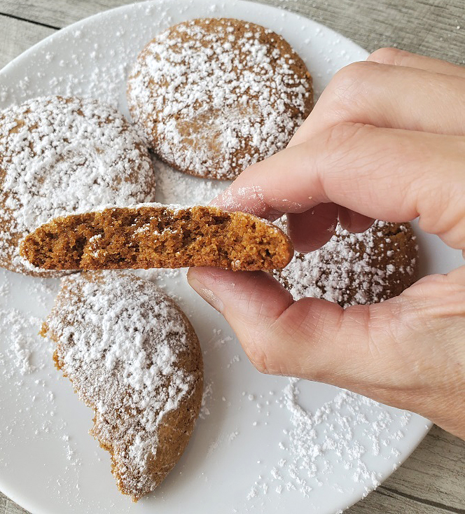 these are old fashioned molasses cookies and cut in half to see the inside the rest on a white plate