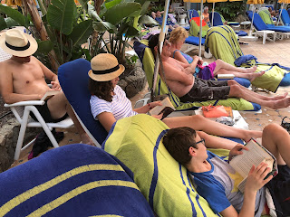 Family reading by the pool in Gran Canaria