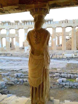 A caryatid looking out at the Parthenon from the Erechtheion of the Acropolis