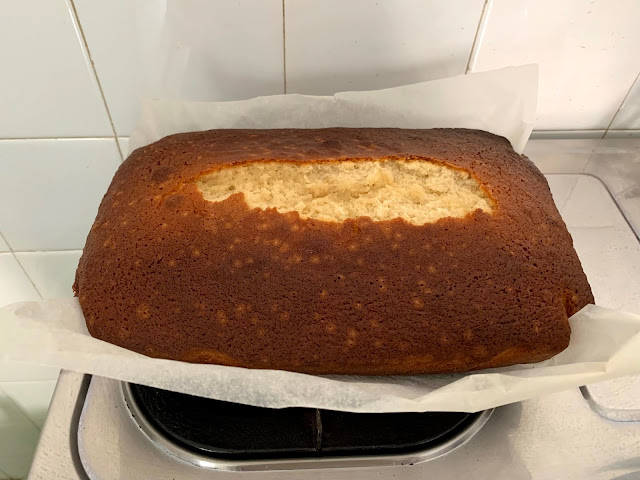 A rectangular vanilla cake in parchment paper