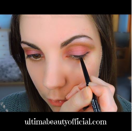 Ultima Beauty lining lower water line of the eye with a pencil eyeliner.