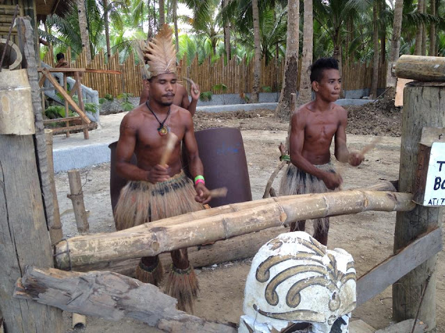 Men of the Ati tribe beating drums