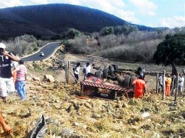 Caminhão carregado de abacaxis capota e deixa motorista ferido em rodovia da Paraíba